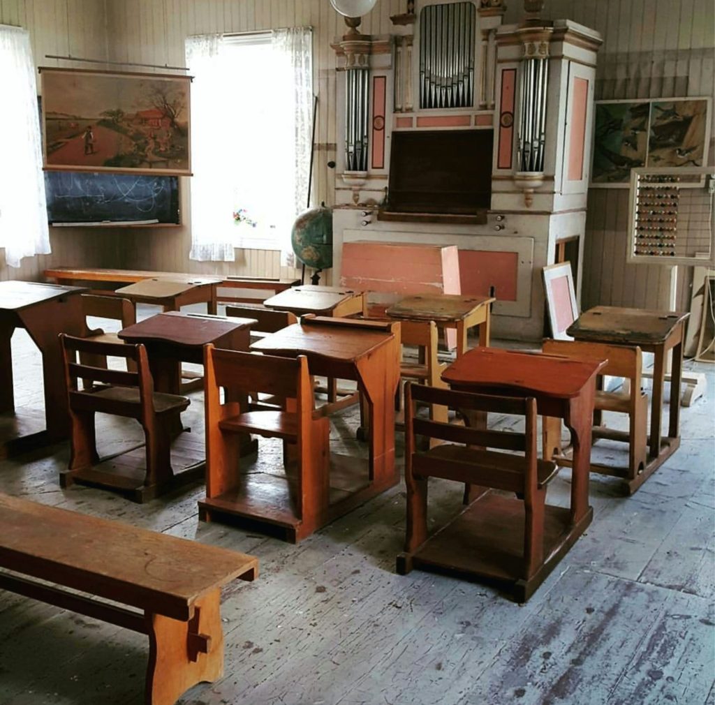 a room filled with wooden desks and benches