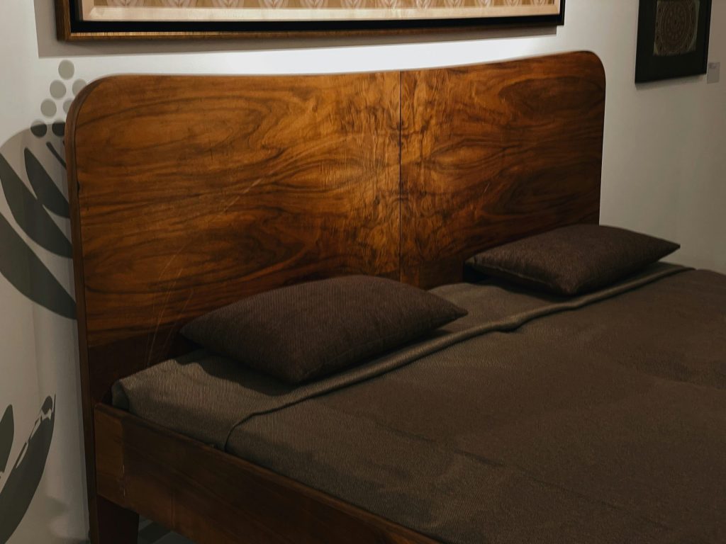 a bed with a wooden headboard and brown sheets